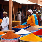 **Niamey Grand Market, Niger:** A vibrant and bustling market scene in Niamey, Niger. Capture the colorful displays of local crafts, fabrics, spices, and traditional goods. Include people interacting and selling items. The overall feeling should be lively and culturally rich.